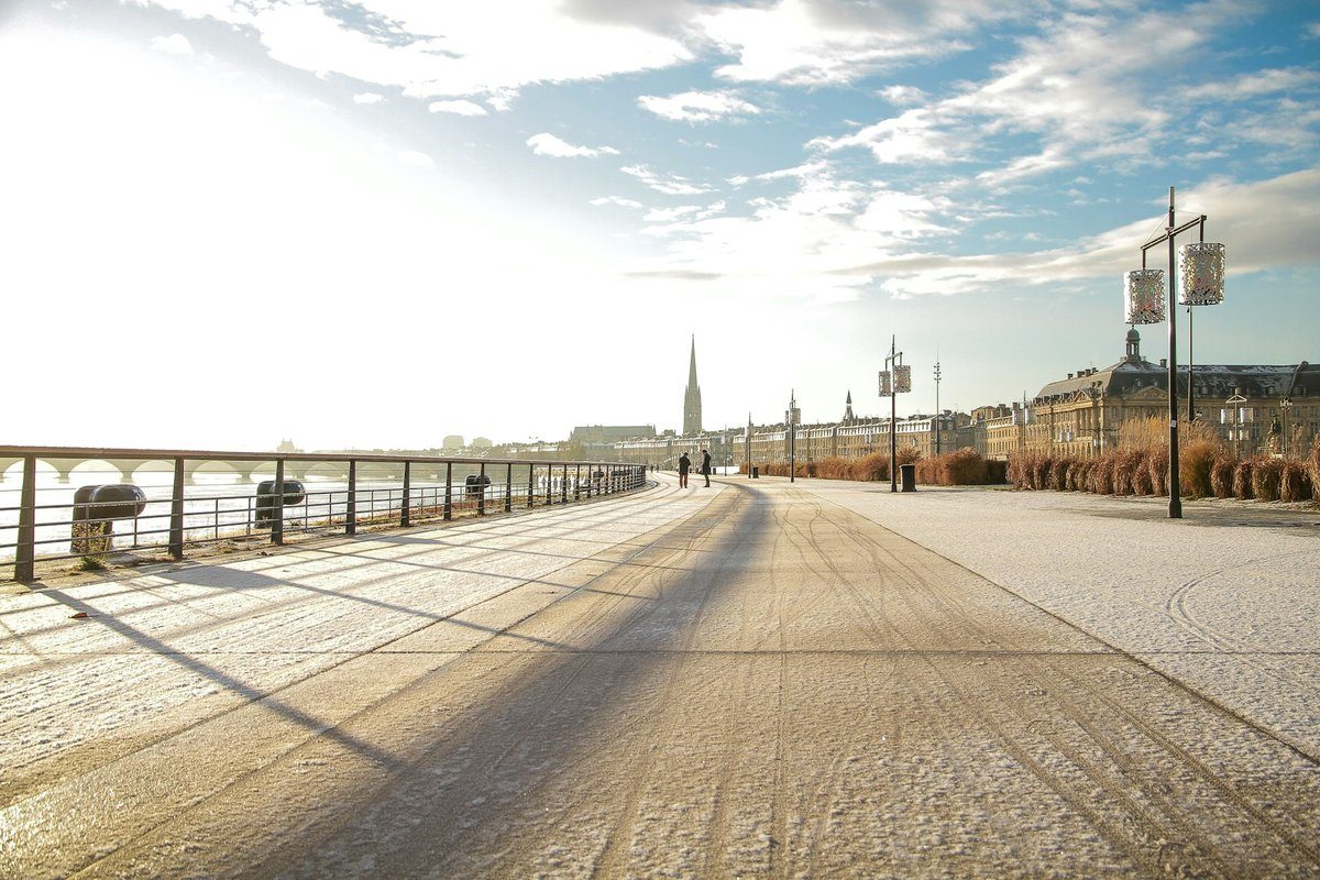 Les quais aménagés de Bordeaux presque vides au petit matin, la flèche Saint-Michel au loin