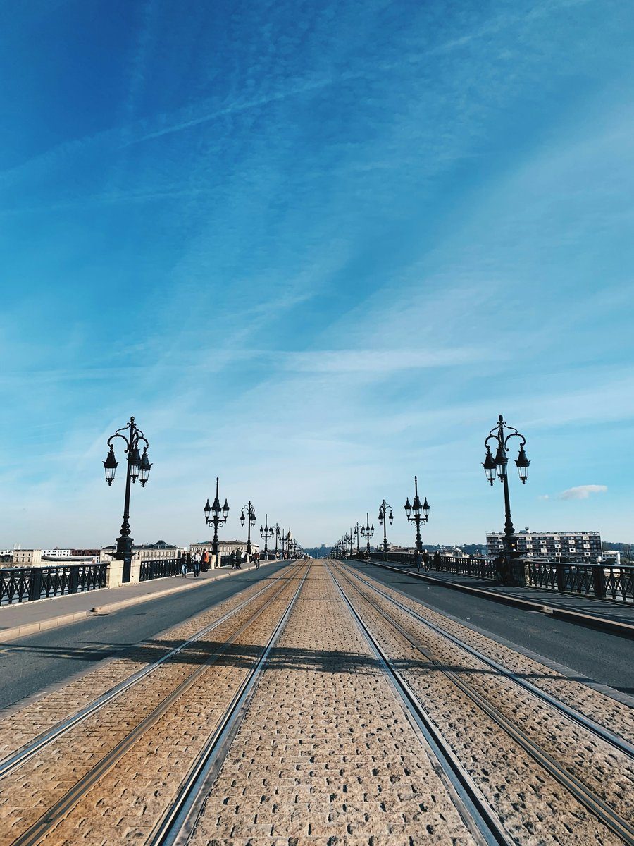 Tablier pavé du pont de pierre avec les rails du tram et une rangée de réverbères